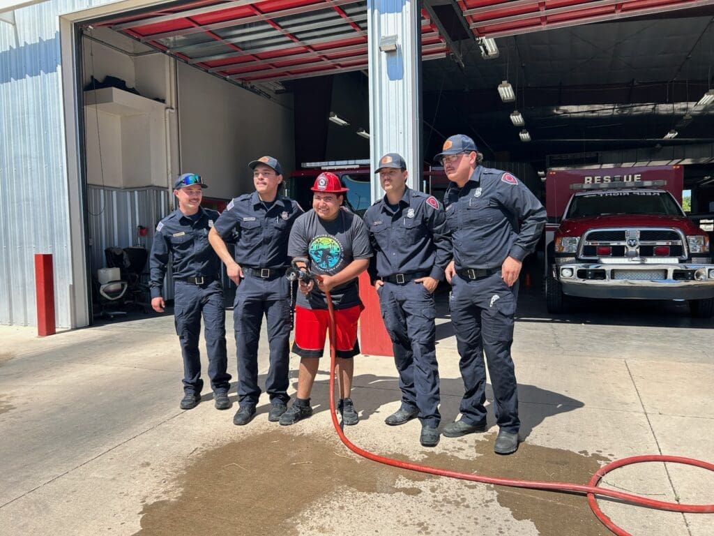 IMG_0717 1 A client posing with Roswell's firefighters at their fire station at an event with Behavior Support Services