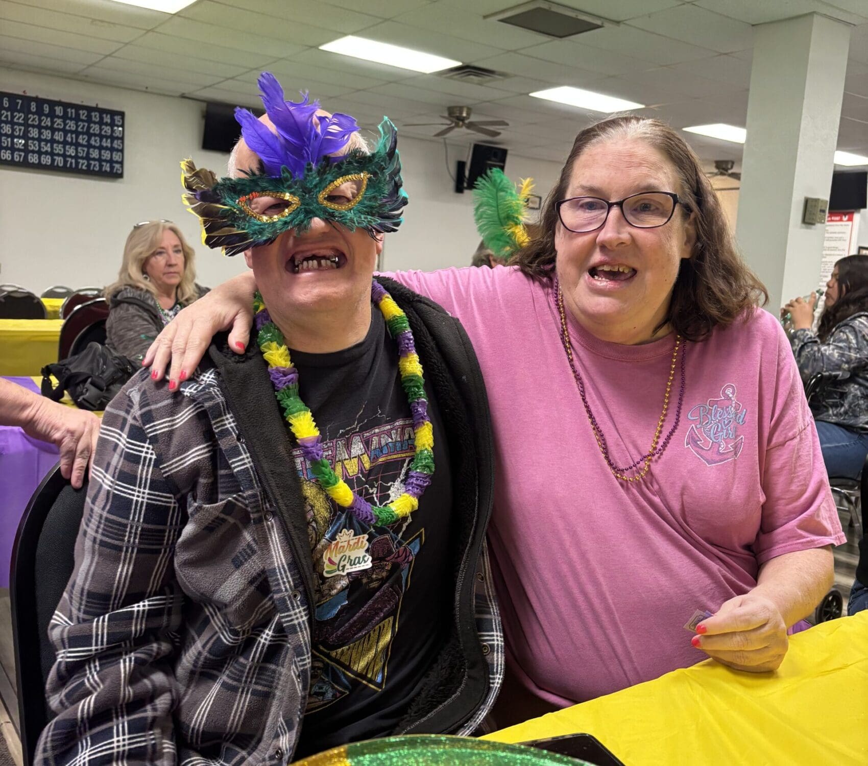 IMG_20250610_092037 Two clients are celebrating Mardi Gras with masks and hats